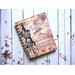 A blank notebook with a vintage ephemera cover and coffee stained paper