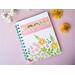 a blank notebook with turquoise lined paper that has a flower cover that says grow