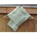 Display of the V-stitch Crochet Scarf pattern on a hanger in front of a wooden fence.