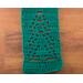 Close-up of a green scarf showing details of a tree in the pattern.