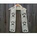 Display of the Ghost Crochet Scarf on a hanger in front of a wooden fence.