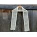 Display of the Diagonal Crochet Scarf Pattern on a hanger in front of a wooden fence.