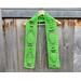 Display of the Balloon Crochet Scarf Pattern on a hanger in front of a wooden fence.