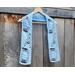 Display of the Dad Crochet Scarf on a hanger in front of a wooden fence.