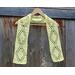 Display of the Diamond Crochet Scarf on a hanger in front of a wooden fence.