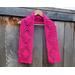 Display of the Diamond Crochet Scarf Pattern on a hanger in front of a wooden fence.