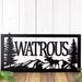 Close up of metal family name plaque with moose and mountains, in matte black powder coat.