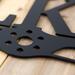 Close up of pilot family name metal sign with propeller, in matte black powder coat.