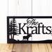 Close up of rectangular custom metal sign with moose and pine trees, in matte black powder coat.