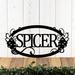 Hanging oval family name metal sign with grapes and grapevines, in matte black powder coat.