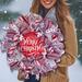 Woman holding rustic holiday wreath with red and white ribbons, glitter snowflakes, and festive farmhouse Christmas accents.