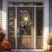 Farmhouse fall tobacco basket wreath with berries, greenery, and a 'Fall Is In The Air' sign on a glass-paneled front door. Autumn decor.