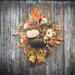 Cozy fall wreath with velvet pumpkins, autumn leaves, and florals for warm harvest decor on your front door.