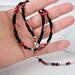 Black and red heart choker in hand.