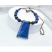 Necklace with blue lapis lazuli trapezoidal prism pendant, copper spacer beads, and round lapis lazuli beads on copper chain with hook clasp