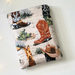 cowboy boots book sleeve has a light rustic brown background, there are cacti and boots, some had cowboy hats on top of them