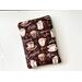 this coffee book sleeve has a checkered brown background with different coffee names and coffee