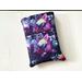 This galaxy book sleeve with pocket is sparkly with different shades of purple with planets all over the space book cover