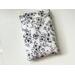 this floral book sleeve has a white background with black floral