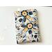 this floral book sleeve has a white background with navy, blue and gold flowers and leaves