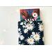 a small book peeking out of the daisy book holder