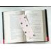 this bug bookmark is lying on top of a open book