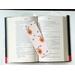 insect bookmark is lying on top of a open book