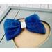 Close up of navy blue 4 x 3 glitter tulle hair bow. Brought together with a piece of white glitter faux leather.  Bow is sold individually.
