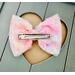 Back view of textured floral inspired soft pink, peach, blue, & yellow, hair bow, with pink sparkle shell charm on top. 