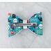 Back view of the Teal & black Halloween print hair bow with loops of white ribbon. 4 layers total. Bow is approx. 3 1/2 x 2 1/2. 