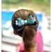 My 4 year old daughter modeling the Teal & black Halloween print hair bow with loops of white ribbon. 4 layers total.