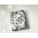 this floral kindle sleeve has a white background with black flowers and vines
