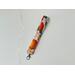 this orange keychain wristlet has a light pink background with tiny white polka dots with citrus orange all over the key strap