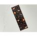 this Halloween candy bookmark has a black background with large candies surrounded by smaller candies