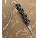 Large black beads with silver tone accents, large shepherd hook, and a 3D flute Charm.