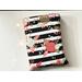 this floral book sleeve has a black & white stripe background. the flowers and leaves are in colors gold, light blue, and pink