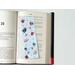 laminated bookmark is on a open book resting on a page