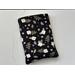 this floral book sleeve has a black background with white flowers and green and purple leaves