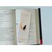 this laminated bookmark is on top of an open book