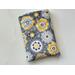 this floral book sleeve has a gray background with light gray, yellow, white and black flowers all over the book pocket