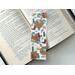 this country bookmark is on top of an open book on a white table
