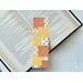 the fall bookmark is on top of an open book with a pair of glasses above the book on a white table