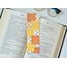 this fall patchwork bookmark has blocks of yellow, orange white blocks. Each block has a different pattern. Either fall leaves or fall flowers