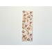 the floral bookmark is on a white table