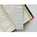 this elegant bookmark has a white background with small green leaves and light and dark pink roses all over the book mark