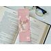 this Xmas bookmark is on top of an open book with a pair of glasses above the book with fairy lights peeking out on the right side