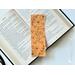 this yellow floral bookmark has a mustard yellow background with black outlines of flowers all over the bookmark