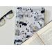 book pocket is on a white table with an open book on top and a pair of glasses on the left side