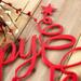 Close up of red gloss powder coat on our Happy Holidays metal wall art.