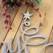 Close up of raw steel on our Happy Holidays metal wall art.